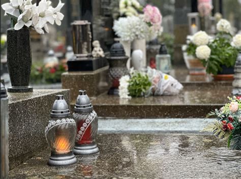 skupina ľudí na cintoríne s horiacimi sviečkami na hroboch