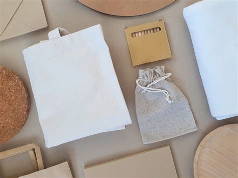 Koláž rôznych ekologických baliacich materiálov: hnedý kraft papier, látkové vrecúška, sušené pomaranče, šišky, vetvičky ihličnanov a staré noviny.