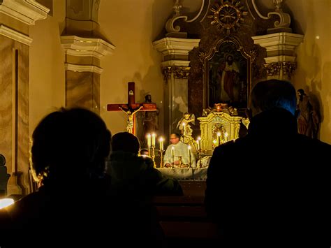 Fotografia rorátnej omše s kostolom osvetleným len sviecami