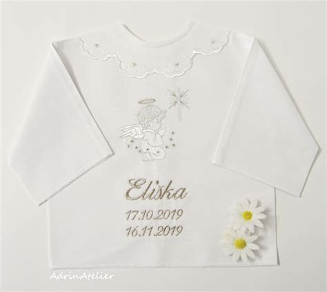 Detailná fotografia ručne vyšívanej krstnej košieľky s detailom mena a dátumu krstu