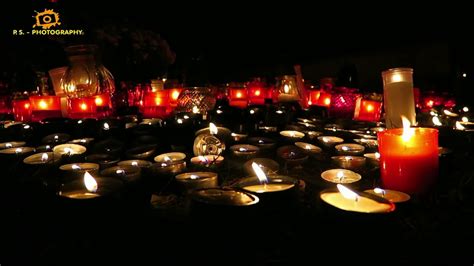 Tematická fotografia kontrastujúca pokojnú atmosféru horiacich sviečok na cintoríne a tradičnú halloweensku výzdobu s tekvicami