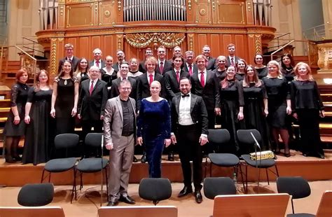 Zbor vystupujúci na pódiu s dirigentom