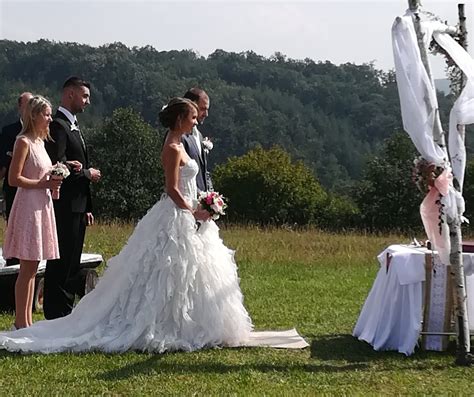 fotografia stodoly s jednoduchou svadobnou výzdobou, vonku sa nachádza svadobný obrad
