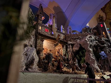 Betlehem v kostole a koledníci pri dverách rodinného domu