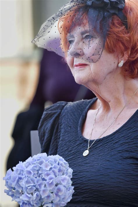 Portrét učiteľky s usmievavou tvárou, obklopená kvetmi