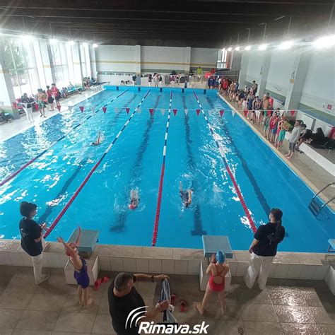 Tematické foto: Skupina plavcov objíma svojho trénera pri bazéne.