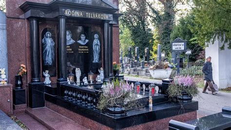 Zdobené hroby s kvetmi a horiacimi sviečkami na cintoríne