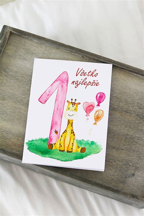 Koláž rôznych dizajnov pozvánok na prvé narodeniny s rôznymi motívmi (zvieratká, čísla, abstraktné vzory).