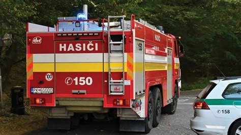 Hasiči zasahujúci pri požiari dvoch áut pod prístreškom