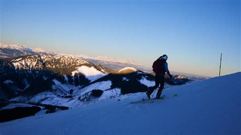 Panoramatické foto zasnežených Vysokých Tatier s lyžiarmi
