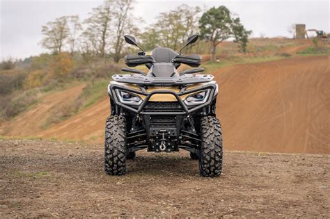 Tematická fotografia štvorkolky v akcii na off-road trati, s rozstrekujúcim sa blatom