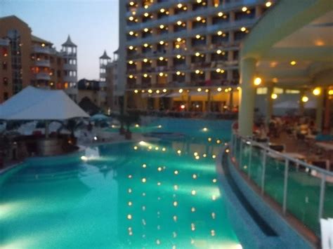 Rodina oddychujúca pri bazéne v tropickom hoteli