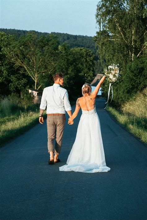 Svadobné fotografie páru pri jazere obklopenom lesom