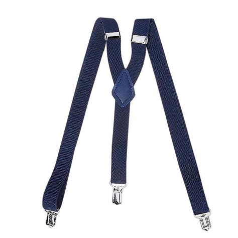 Muž v elegantnom, no neformálnom oblečení (košeľa, traky, nohavice) na svadbe v stodole.