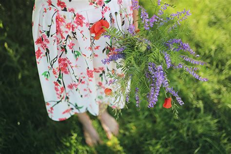 Nevesta v jednoduchých svadobných šatách s kyticou z lúčnych kvetov.