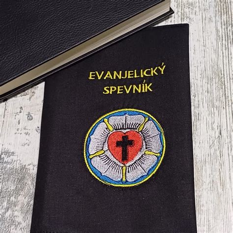 Záber na otvorený Evanjelický spevník položený na lavici v kostole s vianočnou výzdobou v pozadí