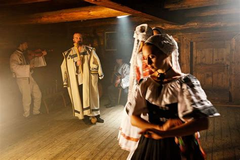 Detailný záber na drevené postavičky v ľudových krojoch pri každodenných remeselných prácach.