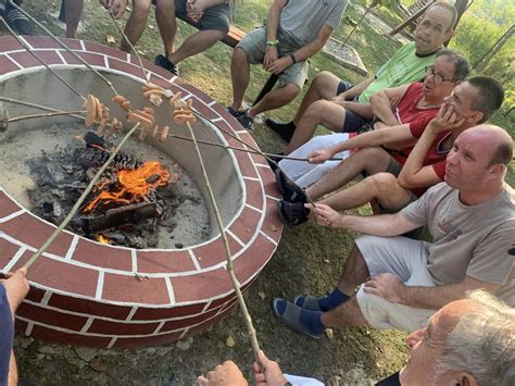 Deti opekajúce si klobásky a marshmallows pri otvorenom ohnisku v parku