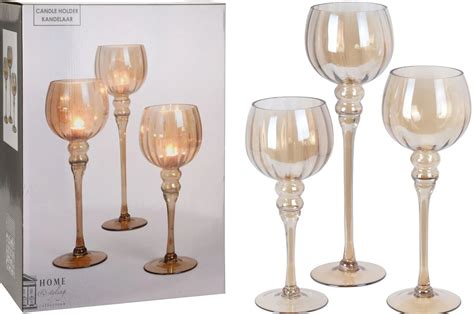 Dekoratívna kompozícia nástenných a stolových sklenených svietnikov v modernom interiéri