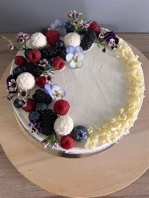 Fotografia luxusnej torty na mieru, zdobenej čerstvými kvetmi a ovocím, s mascarpone krémom