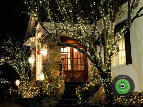 vianočne osvetlený exteriér domu so svetelnými reťazami a dekoráciami na dverách