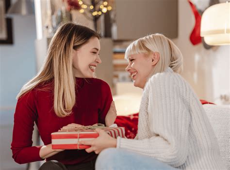 Tematické foto: usmiaty pár, žena dáva darček mužovi