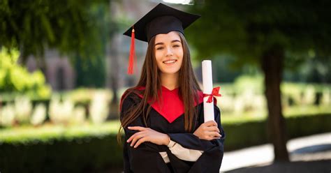 fotografia šťastného absolventa s diplomom v ruke počas promócie