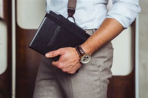 Muž s elegantnými hodinkami a koženou peňaženkou