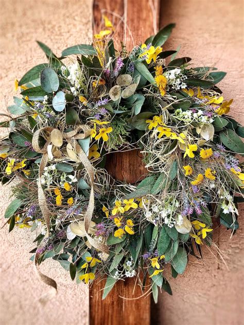 Ilustračná fotografia jarného venca s kvetmi a vajíčkami na dverách