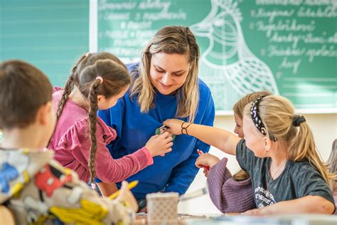 fotografia usmievajúcej sa triednej učiteľky s triedou