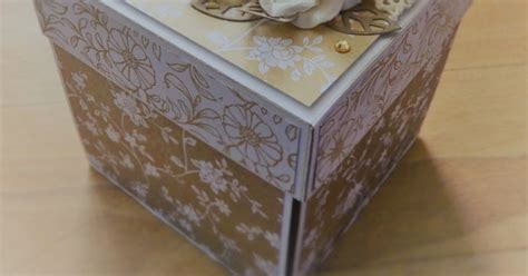 Detail interiéru exploding boxu s pozadím zdobeným jemným papierom a nalepenými symbolmi súvisiacimi so svätým prijímaním.