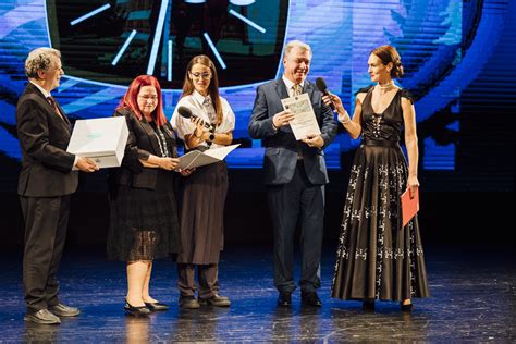 Tematické foto: Skupina žiakov a učiteľov oslavujúca výročie školy s tortou a balónmi