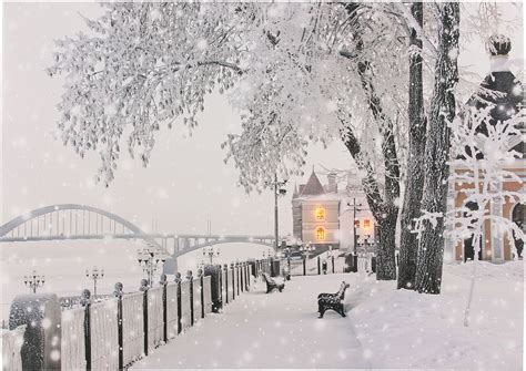 Zimná krajina pokrytá snehom a v pozadí vianočne osvetlený dom