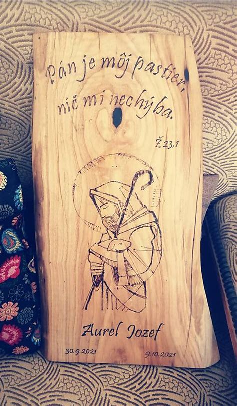 Detail drevenej dosky s biblickým citátom a jemným motívom.