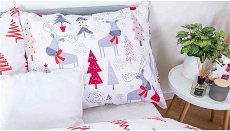 Ilustrácia útulnej obývačky s vianočnými vankúšikmi a sviečkami