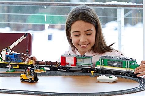 Chlapec hrajúci sa s LEGO stavebnicou, napr. s vlakom alebo dinosaurom.