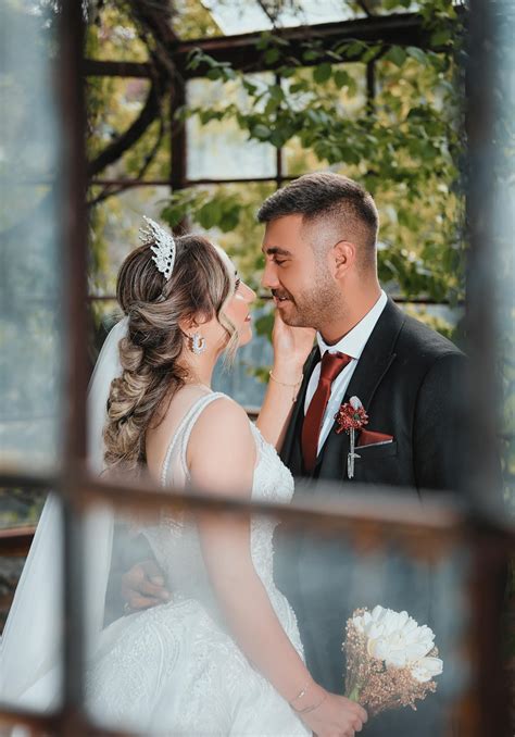 ilustračná fotografia: nevesta a ženích sa smejú na svadbe, v pozadí sú hostia