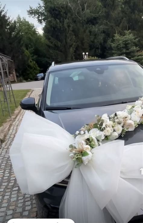 Thematic photo of a white wedding car decorated with elegant white hearts and flowers