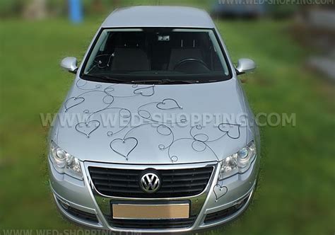 Photo of white rattan hearts on a wedding car