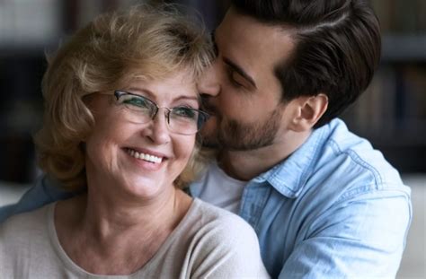 Starsia zena a muz sa usmievaju pri prezerani fotoknihy