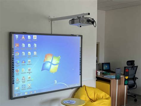 Interaktívna tabuľa v triede s rôznymi tematickými plagátmi