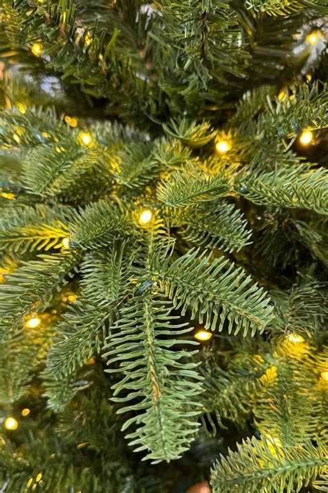 Umelý vianočný stromček s integrovanými LED svetielkami a ozdobami.