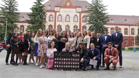 slávnostná školská akadémia s rečníkom na pódiu, v pozadí kvetinová výzdoba a študenti