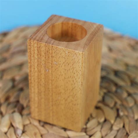 Jednoduchý drevený svietnik s vyvŕtanými otvormi na sviečky