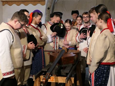 Fotografia: Scéna pochovávania basy, kde muži v parodických kostýmoch plačú a zabávajú sa okolo symbolicky pochovanej basy.