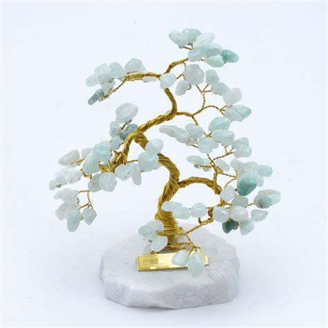 Stromček šťastia z rôznych drahokamov na kamennom podstavci