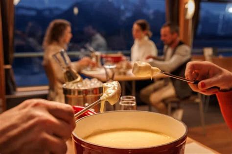 Personen, die gemeinsam ein Käsefondue oder Raclette genießen