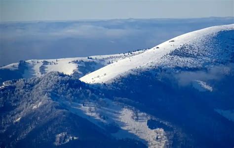 Zimná krajina Nízkych Tatier s lyžiarmi na svahu