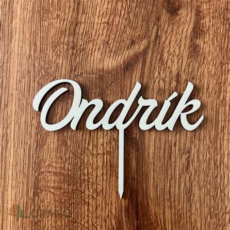 Drevený zápich na tortu s motívom kríža v okrúhlom orámovaní a personalizovaným menom.