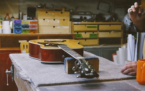 Tematické foto: Ruky hrajúce na gitaru, prípadne rôzne gitarové doplnky rozložené na stole.